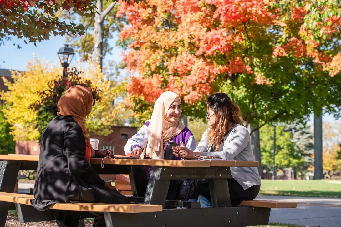 students sitting at picnic table